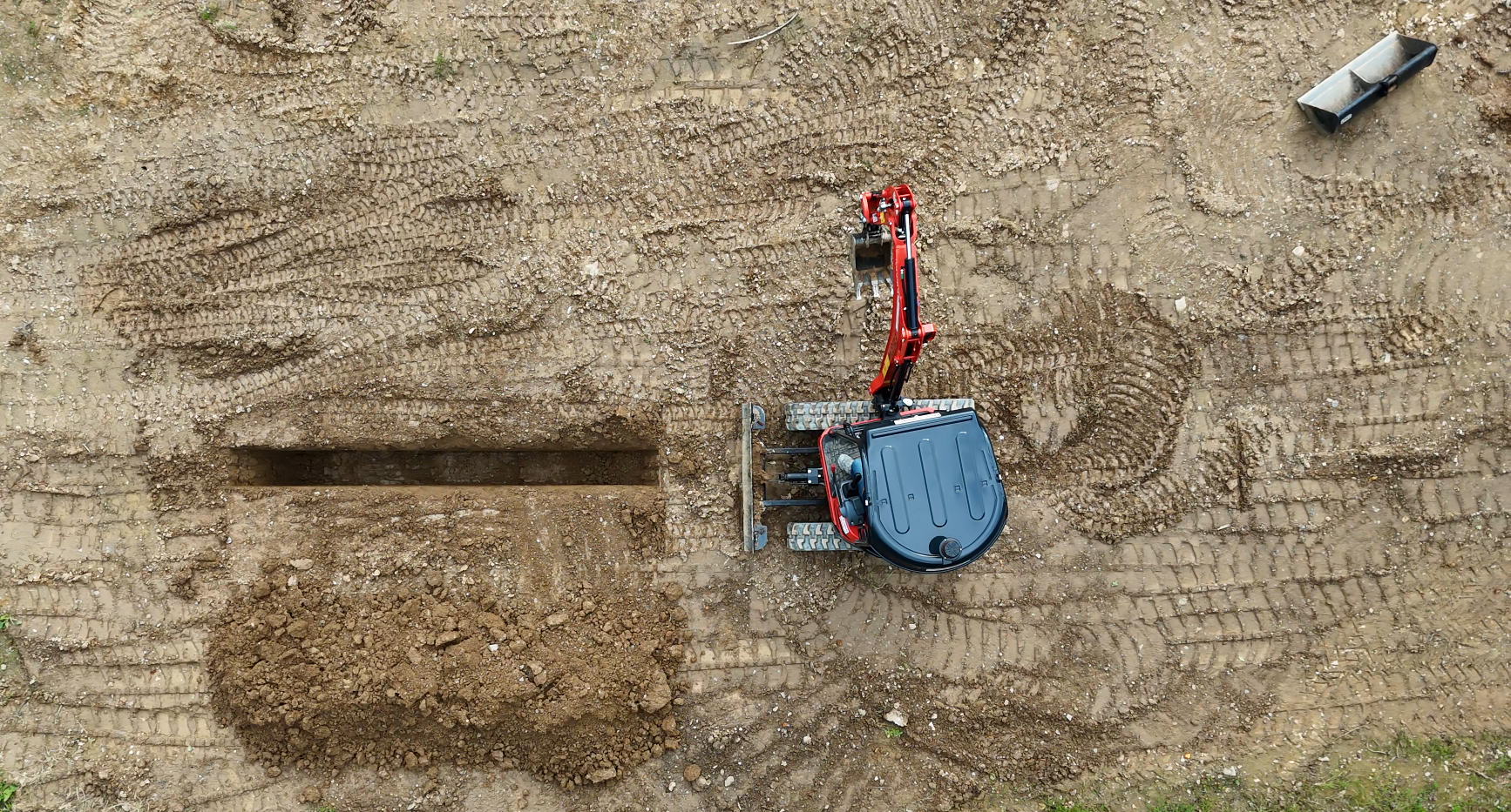 bird's eye view of an excavator digging a trench